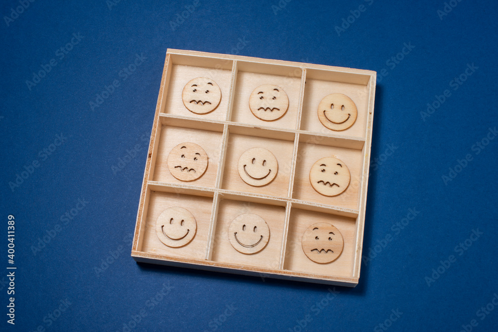 Tick Tack Toe with emoticons made of wooden circles. Positivity wins concept. Tick Tack Toe with emoticons made of wooden circles. Positivity wins concept.