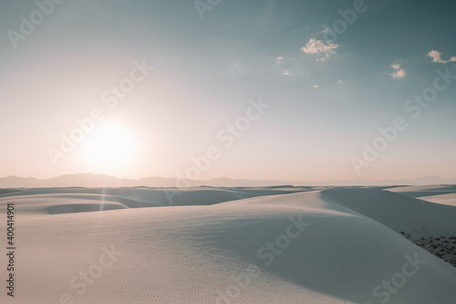 The sun setting over the white gypsum sand dunes creating beautiful shadows and revealing textures in the sand at White Sands National Park, New Mexico, USA.