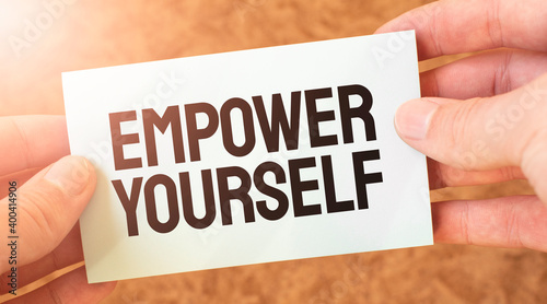 Empower Yourself word inscription on white card paper sheet in hands of a businessman. recap concept. red and white paper