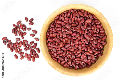 Top view of a bowl of beans. A handful of red beans are scattered nearby.