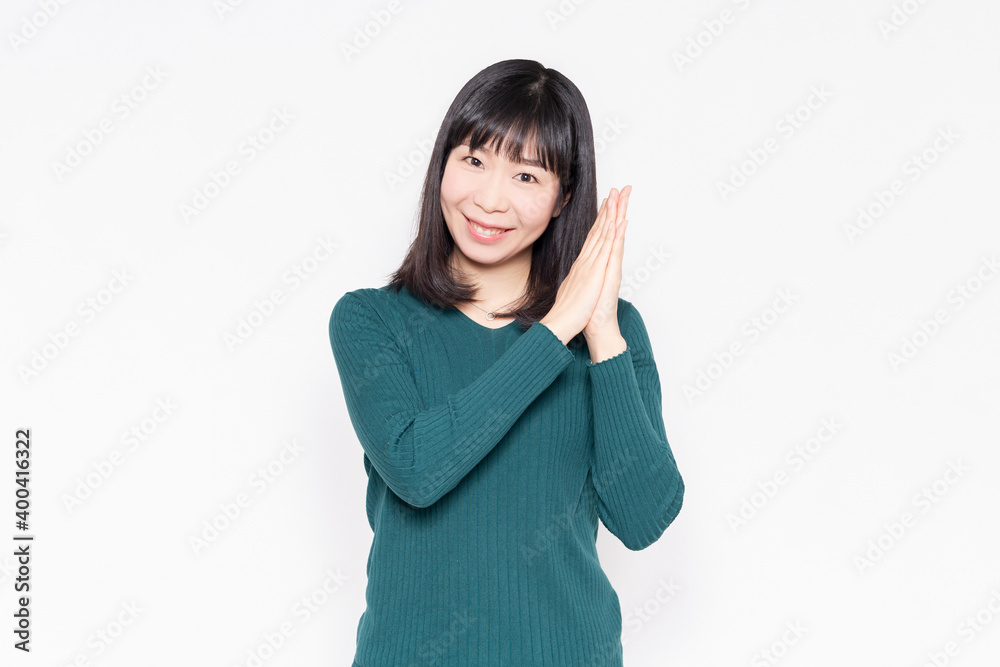 白背景の前でお願いのジェスチャーをする女性 白背景の前でお願いのジェスチャーをする女性