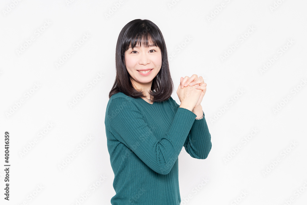 白背景の前でお願いのジェスチャーをする女性