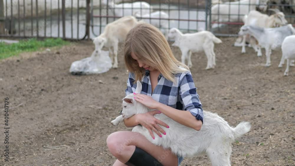 Adorable sexy girl posing with white goat on the farm Adorable sexy girl posing with white goat on the farm