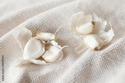 Garlic on white napkin. Eating garlic is claimed to fight infections, has an antiseptic, antibacterial, and anti-fungal agent. It helps the body resist or destroy viruses and other microorganisms.