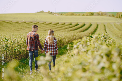 Man and woman in a field on spring day. Couple in love spend time in spring field. Grass on background.