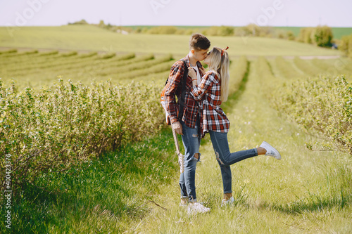 Man and woman in a field on spring day. Couple in love spend time in spring field. Grass on background. Man with electro guitar.
