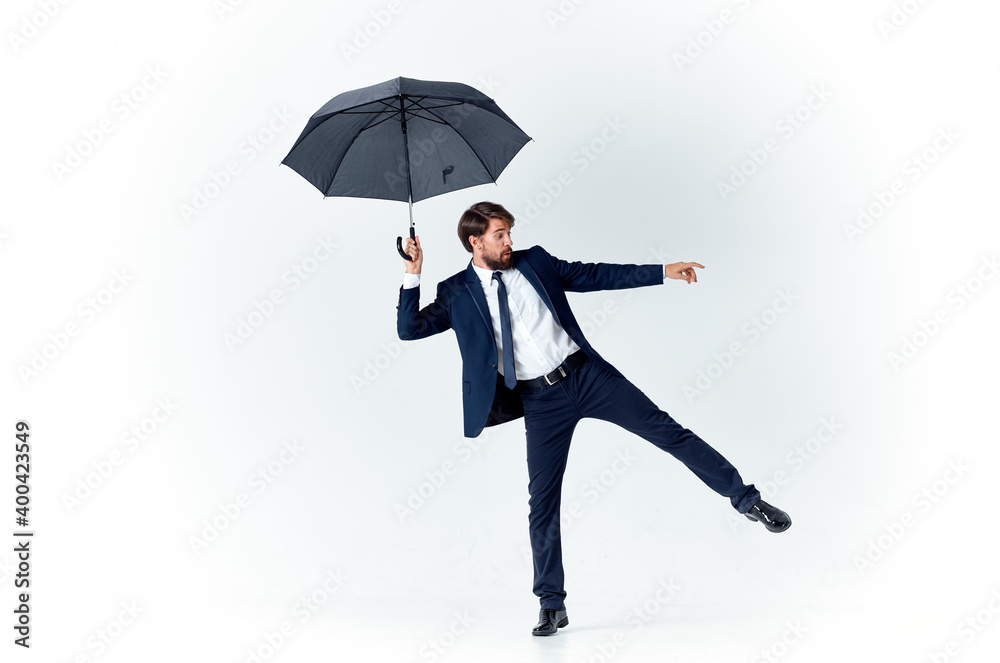 a gentleman with an open umbrella in a dark suit bent to the side a gentleman with an open umbrella in a dark suit bent to the side