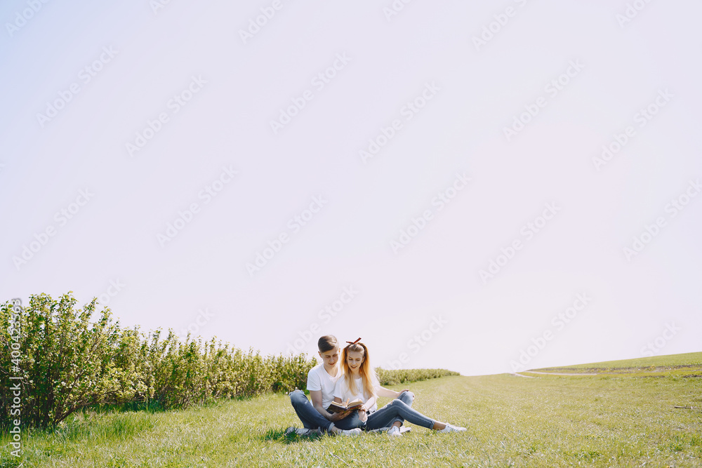 Man and woman in a field on spring day. Couple in love spend time in spring field. Grass on background.