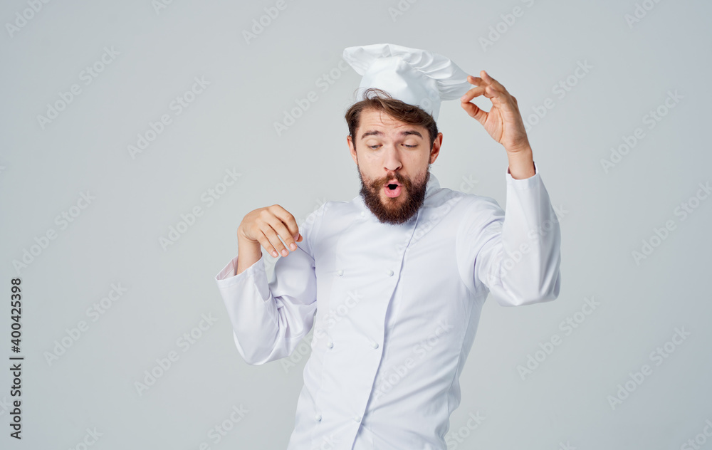 A male chef in a work suit is gesturing with his hands A male chef in a work suit is gesturing with his hands