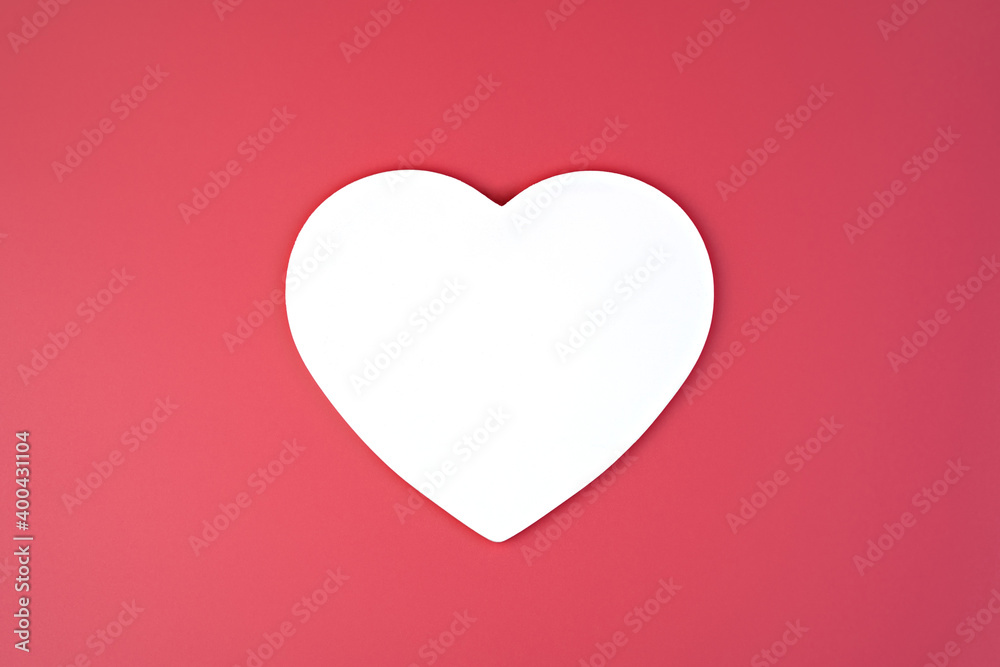 A large white heart on a dark pink background. Top view with space to copy. concept february 14, love.