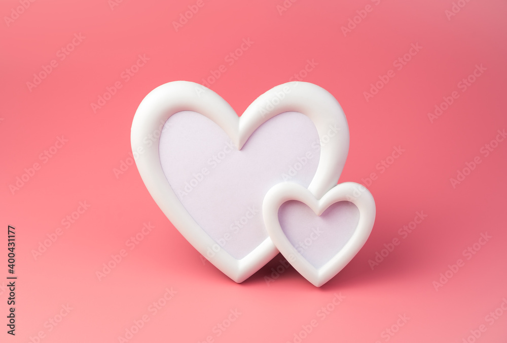 White photo frame in the shape of two hearts on a pink background. Side view, with space to copy. Concept February 14.