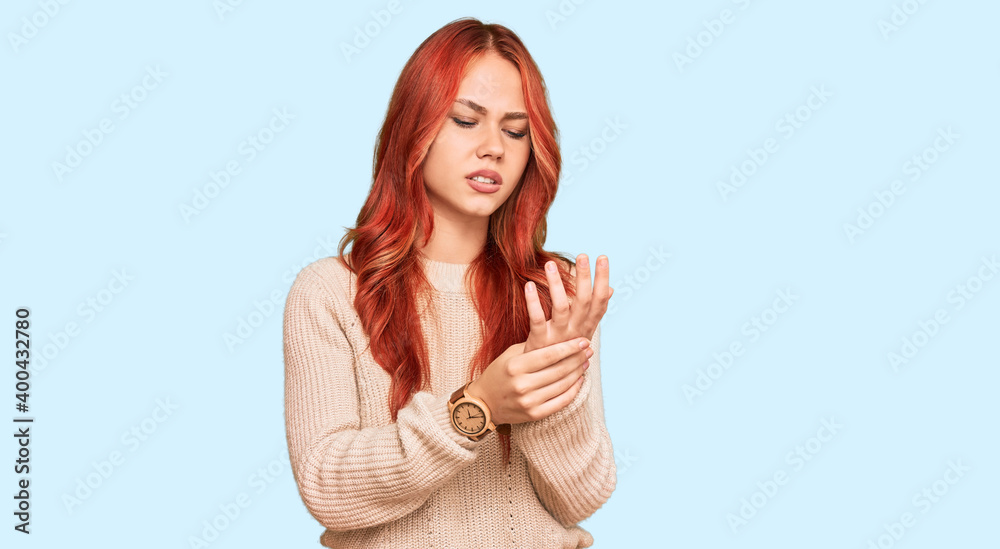 Young redhead woman wearing casual winter sweater suffering pain on hands and fingers, arthritis inflammation Young redhead woman wearing casual winter sweater suffering pain on hands and fingers, arthritis inflammation