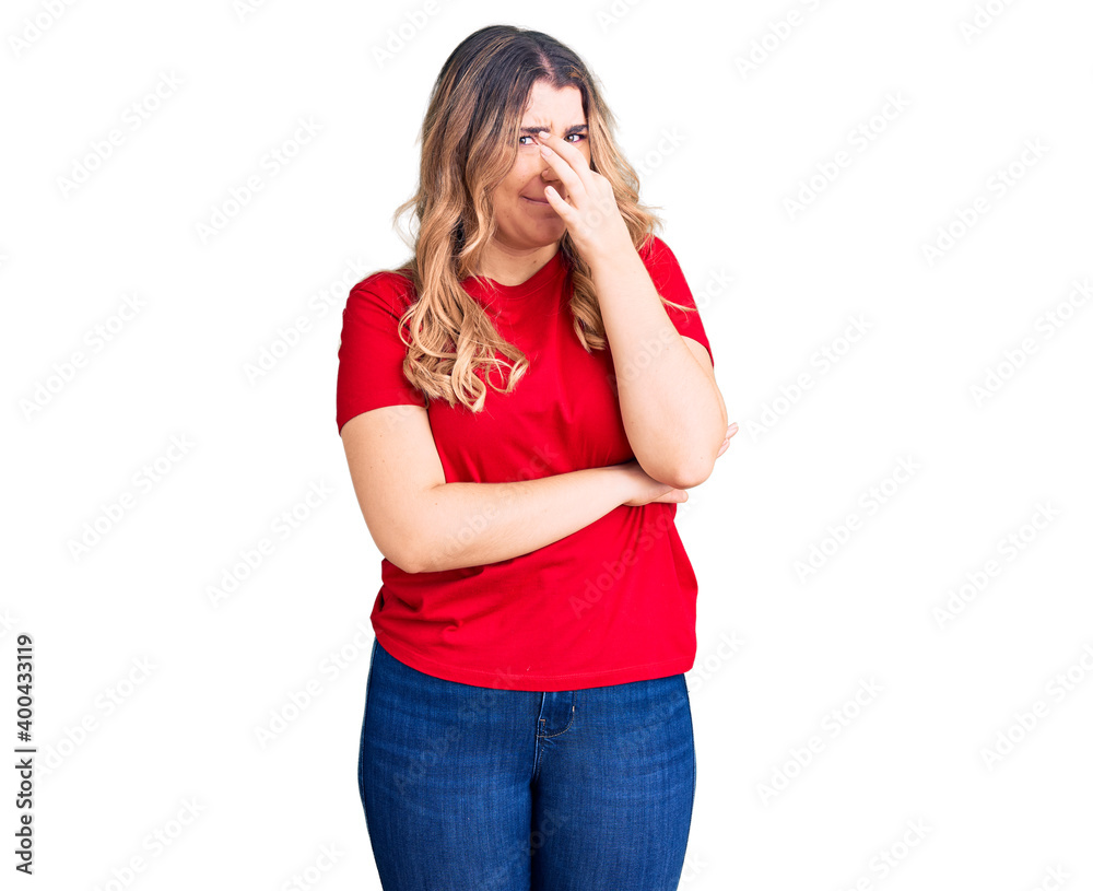 Young caucasian woman wearing casual clothes smelling something stinky and disgusting, intolerable smell, holding breath with fingers on nose. bad smell Young caucasian woman wearing casual clothes smelling something stinky and disgusting, intolerable smell, holding breath with fingers on nose. bad smell