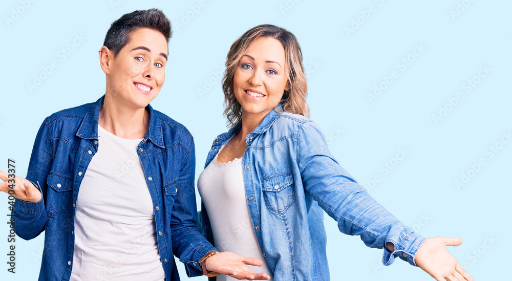 Couple of women wearing casual clothes smiling showing both hands open palms, presenting and advertising comparison and balance Couple of women wearing casual clothes smiling showing both hands open palms, presenting and advertising comparison and balance