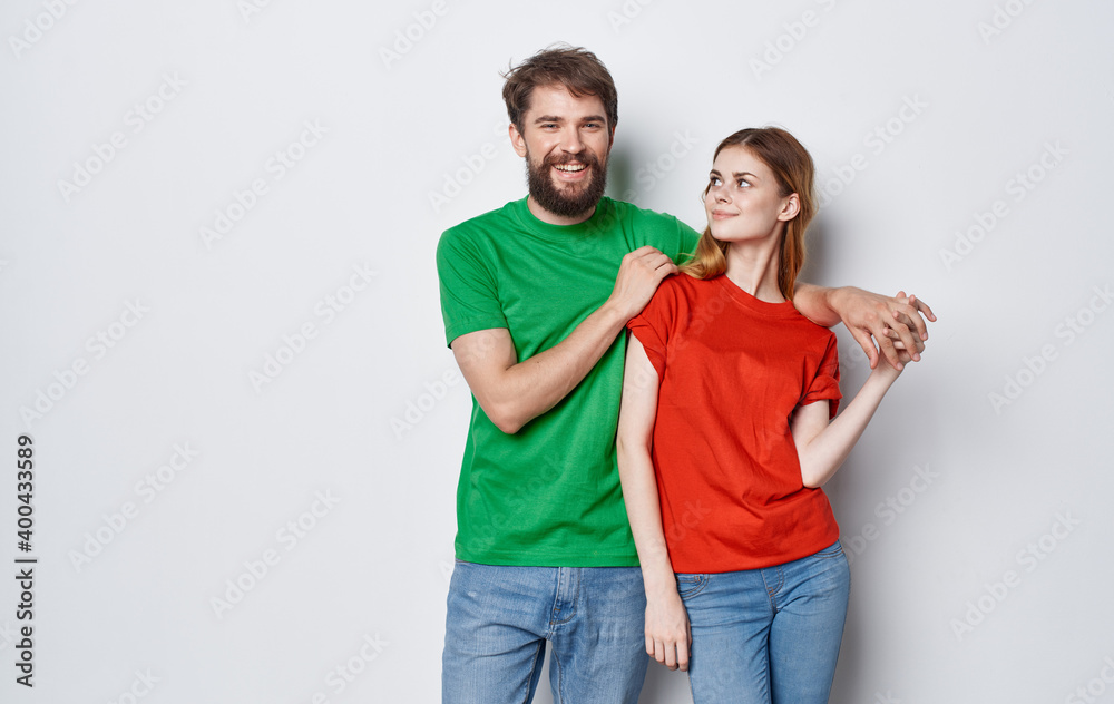 Fototapeta premium cute young couple in multicolored t-shirts hugs lifestyle fun isolated background