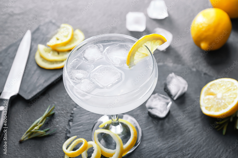 Glass of tasty martini with lemon on dark background Glass of tasty martini with lemon on dark background