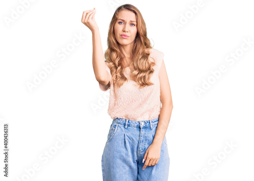 Young beautiful caucasian woman with blond hair wearing casual clothes doing italian gesture with hand and fingers confident expression