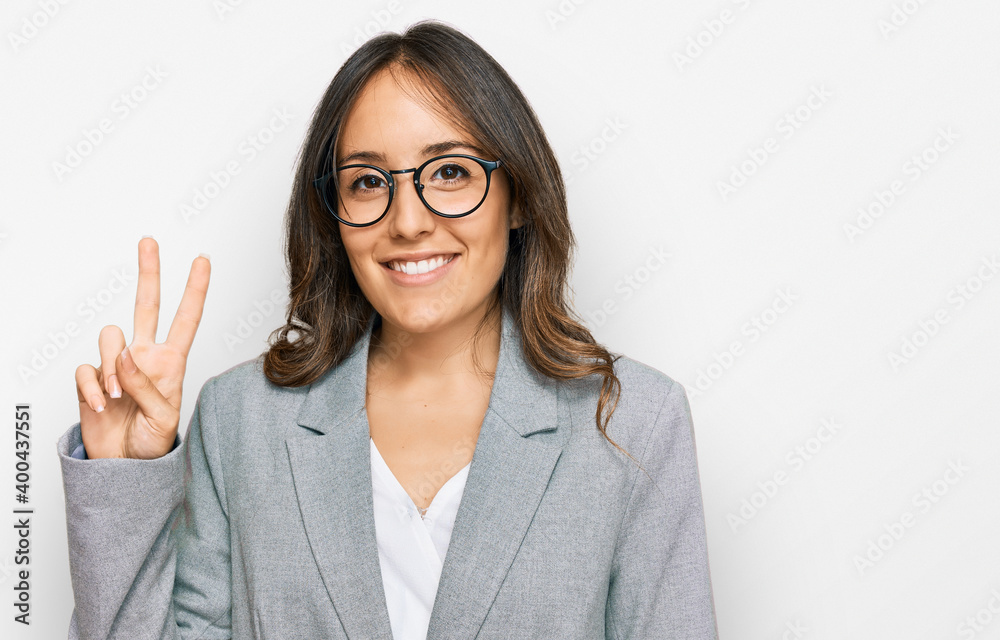 Young brunette woman wearing business clothes showing and pointing up with fingers number two while smiling confident and happy. Young brunette woman wearing business clothes showing and pointing up with fingers number two while smiling confident and happy.