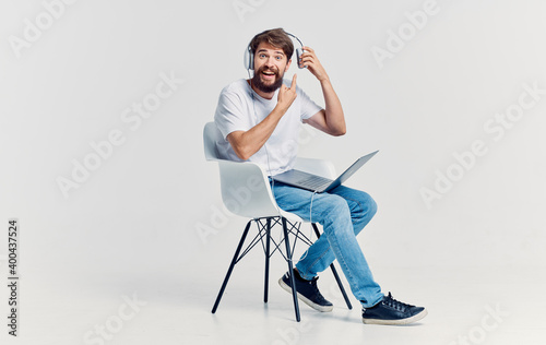 Man sitting on a chair in front of laptop headphones rest office internet technology © SHOTPRIME STUDIO