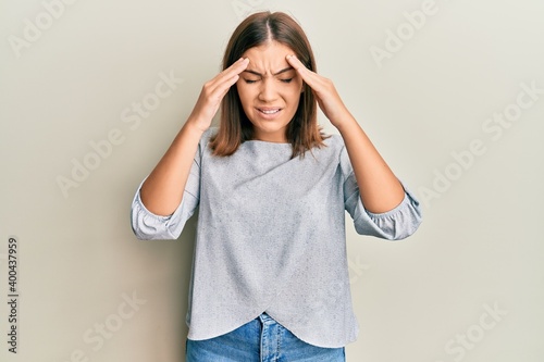 Quadro su tela Young beautiful woman wearing casual clothes with hand on head, headache because stress