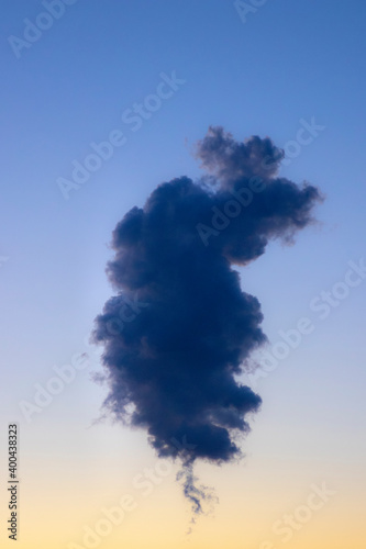 Single towering cloud in clear sky at dusk