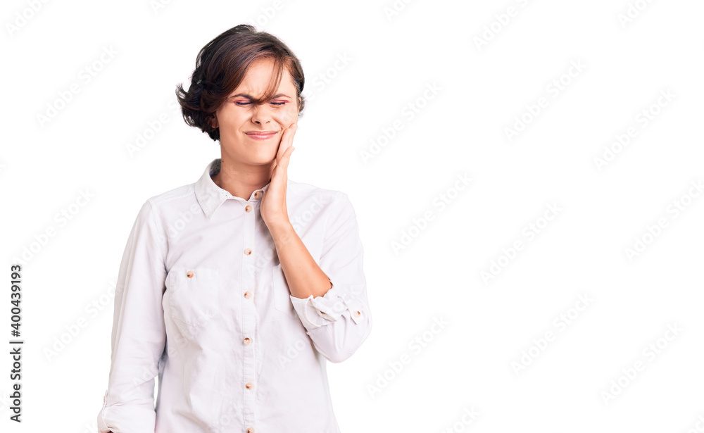 Beautiful young woman with short hair wearing elegant white shirt touching mouth with hand with painful expression because of toothache or dental illness on teeth. dentist Beautiful young woman with short hair wearing elegant white shirt touching mouth with hand with painful expression because of toothache or dental illness on teeth. dentist