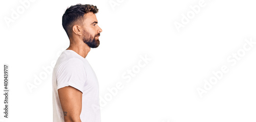 Photography Young hispanic man wearing casual white tshirt looking to side, relax profile pose with natural face with confident smile