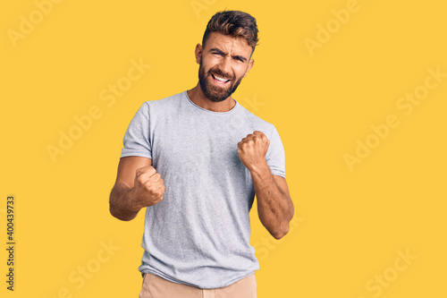 Young hispanic man wearing casual clothes celebrating surprised and amazed for success with arms raised and eyes closed. winner concept.
