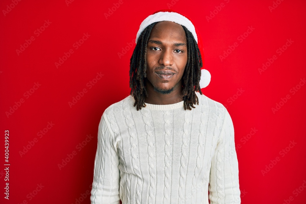 African american man with braids wearing christmas hat looking sleepy and tired, exhausted for fatigue and hangover, lazy eyes in the morning.