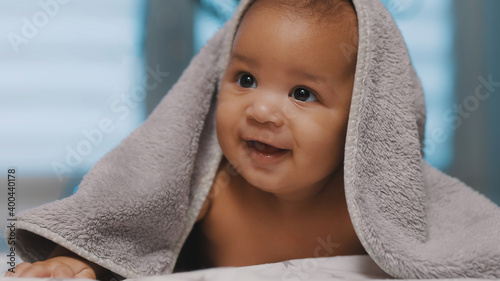 Obraz na płótnie Adorable dark skin baby covered with towel having fun tummy time