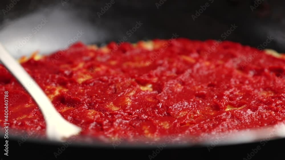 chef puts red tomato paste or sauce on a basic potato pizza. concept of homemade food preparation in a frying pan, close-up chef puts red tomato paste or sauce on a basic potato pizza. concept of homemade food preparation in a frying pan, close-up