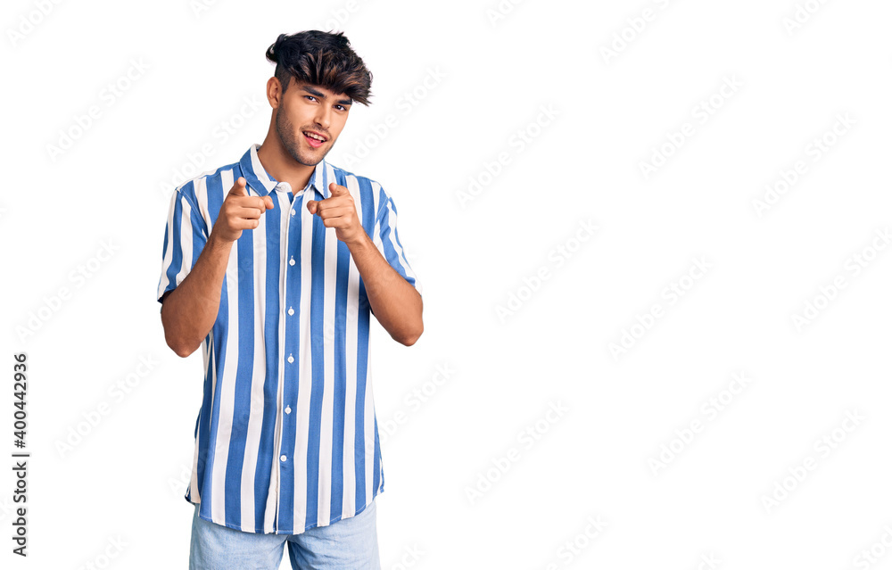 Young hispanic man wearing casual clothes pointing fingers to camera with happy and funny face. good energy and vibes. Young hispanic man wearing casual clothes pointing fingers to camera with happy and funny face. good energy and vibes.