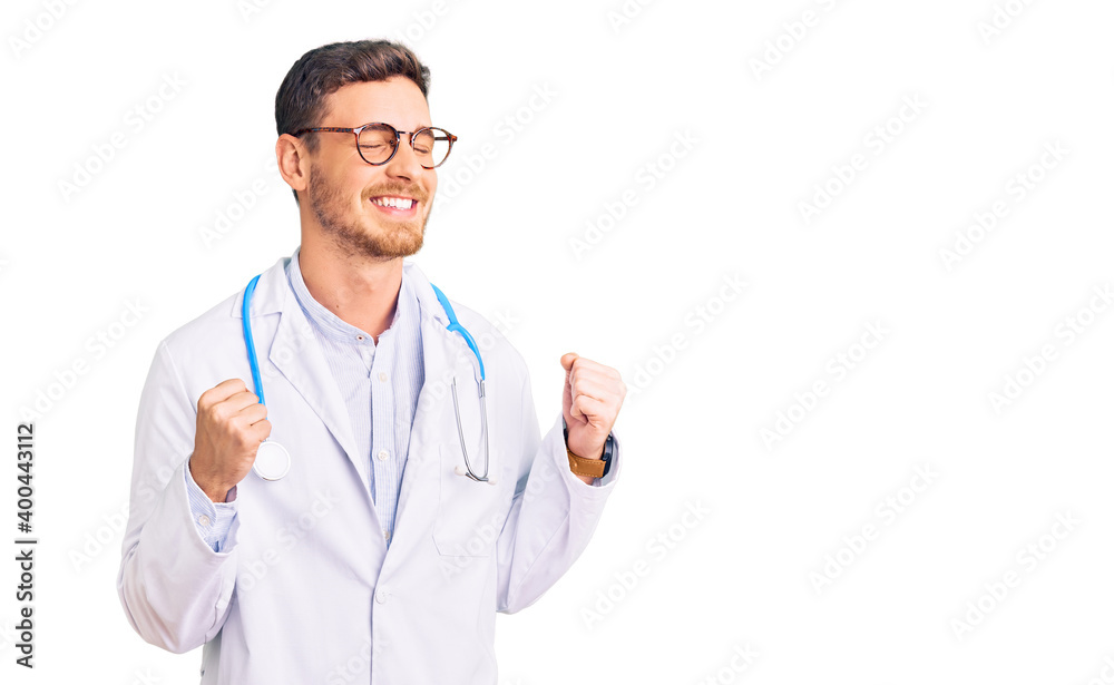 Handsome young man with bear wearing doctor uniform excited for success with arms raised and eyes closed celebrating victory smiling. winner concept. Handsome young man with bear wearing doctor uniform excited for success with arms raised and eyes closed celebrating victory smiling. winner concept.