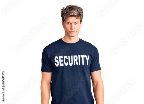 Young handsome man wearing security t shirt skeptic and nervous, frowning upset because of problem. negative person.