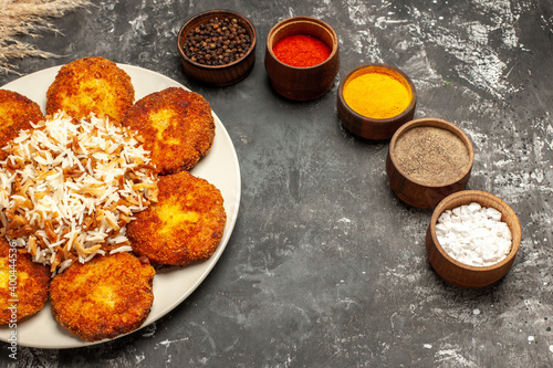 half-top view fried cutlets with cooked rice and seasonings on dark background food meat dish
