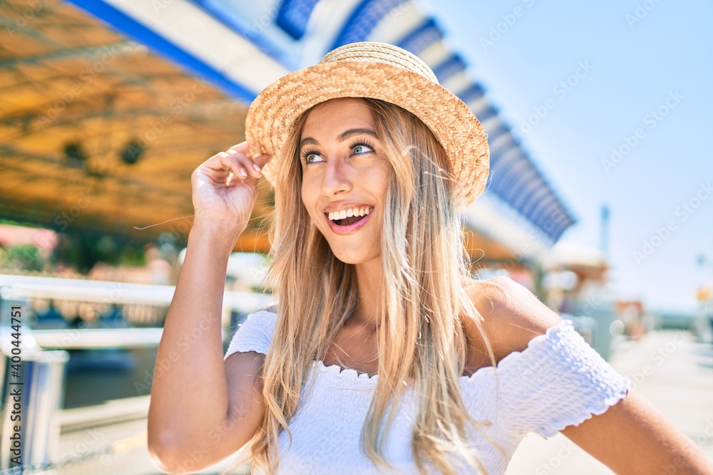 Young blonde tourist girl smiling happy looking to the side at fairground.