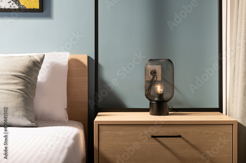 Valokuvatapetti Closeup of modern black metal edison bulb lamp on wooden bedroom night table in
