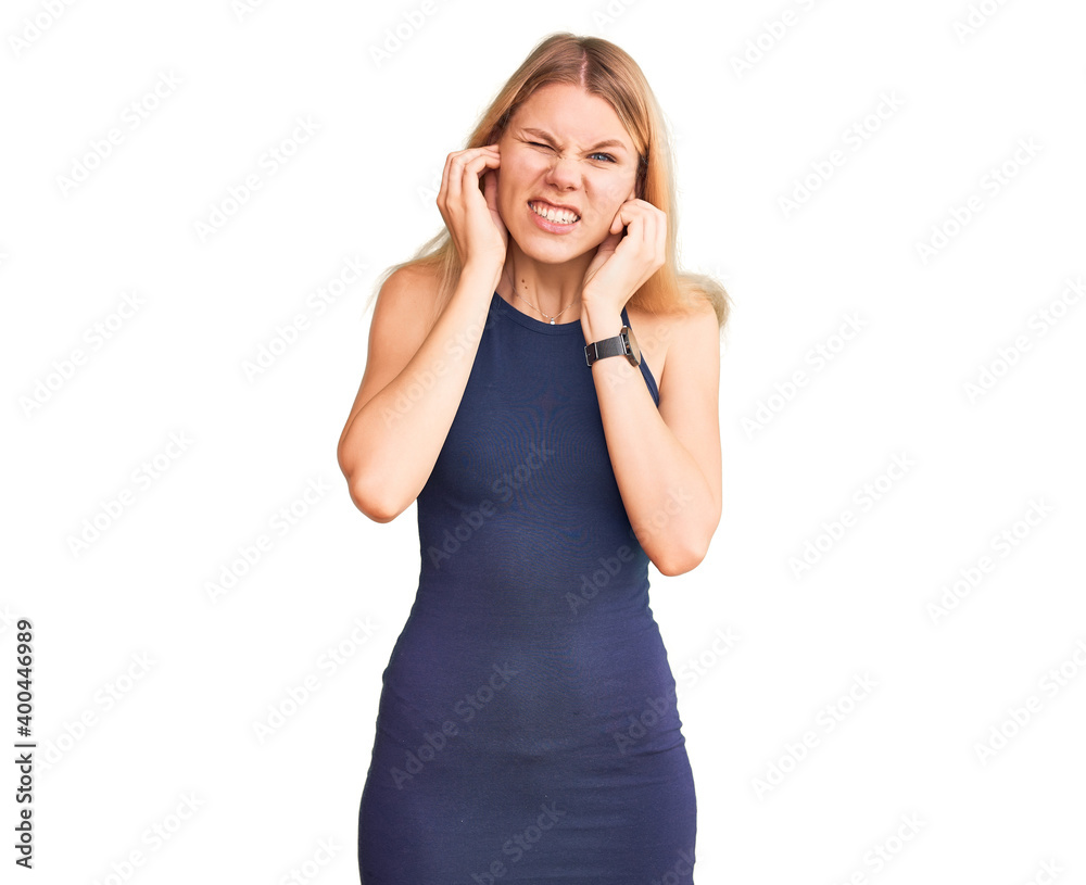 Young beautiful blonde woman wearing casual dress covering ears with fingers with annoyed expression for the noise of loud music. deaf concept. Young beautiful blonde woman wearing casual dress covering ears with fingers with annoyed expression for the noise of loud music. deaf concept.