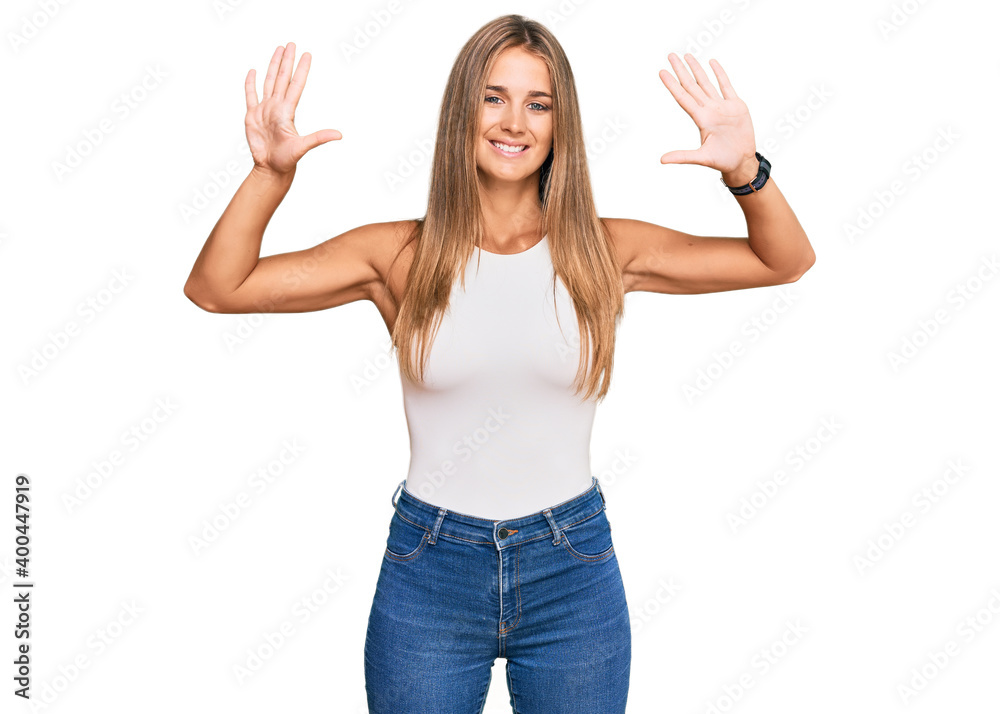 Young blonde woman wearing casual style with sleeveless shirt showing and pointing up with fingers number ten while smiling confident and happy. Young blonde woman wearing casual style with sleeveless shirt showing and pointing up with fingers number ten while smiling confident and happy.