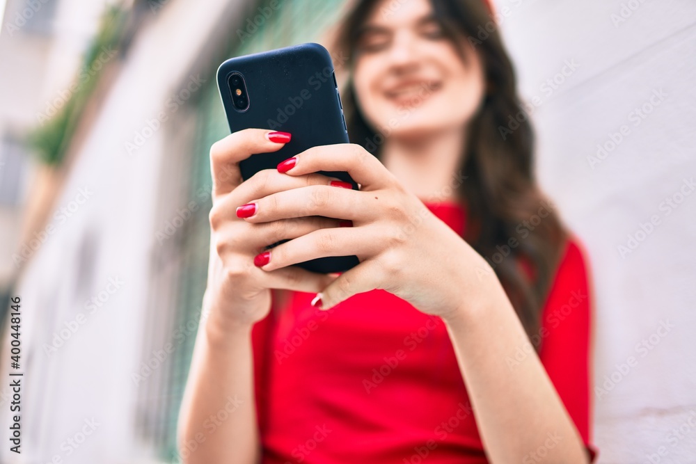 Fototapeta premium Young caucasian woman smiling happy using smartphone at the city.