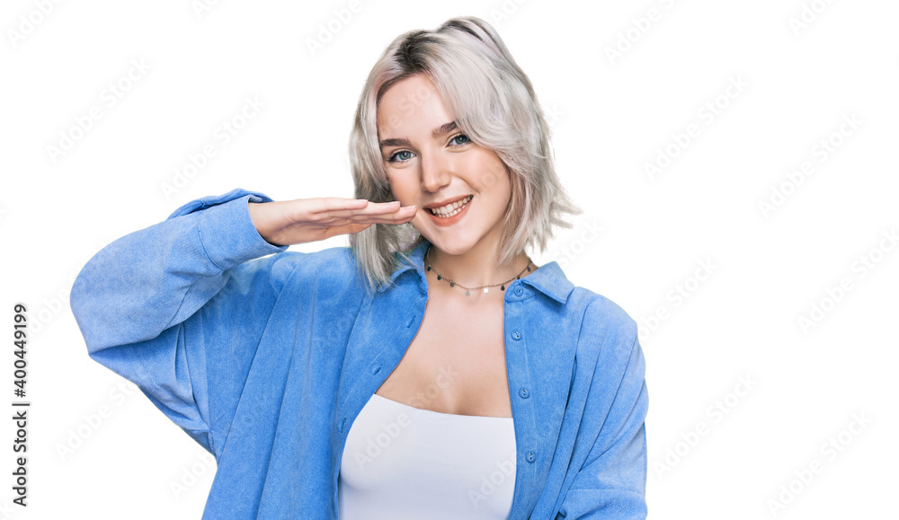 Young blonde girl wearing casual clothes gesturing with hands showing big and large size sign, measure symbol. smiling looking at the camera. measuring concept. Young blonde girl wearing casual clothes gesturing with hands showing big and large size sign, measure symbol. smiling looking at the camera. measuring concept.