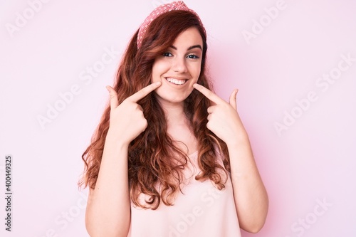 Young beautiful woman wearing casual clothes smiling cheerful showing and pointing with fingers teeth and mouth. dental health concept.