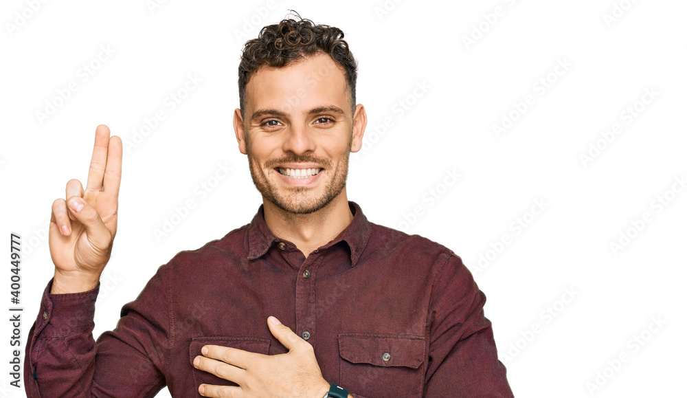 Young hispanic man wearing casual clothes smiling swearing with hand on chest and fingers up, making a loyalty promise oath Young hispanic man wearing casual clothes smiling swearing with hand on chest and fingers up, making a loyalty promise oath