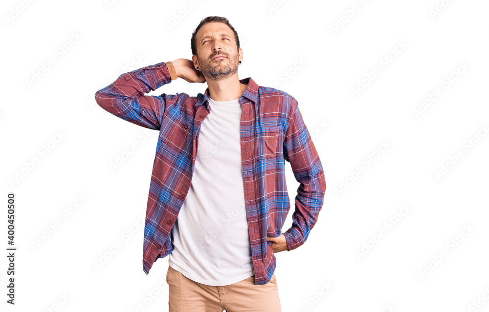 Young handsome man wearing casual clothes suffering of neck ache injury, touching neck with hand, muscular pain Young handsome man wearing casual clothes suffering of neck ache injury, touching neck with hand, muscular pain