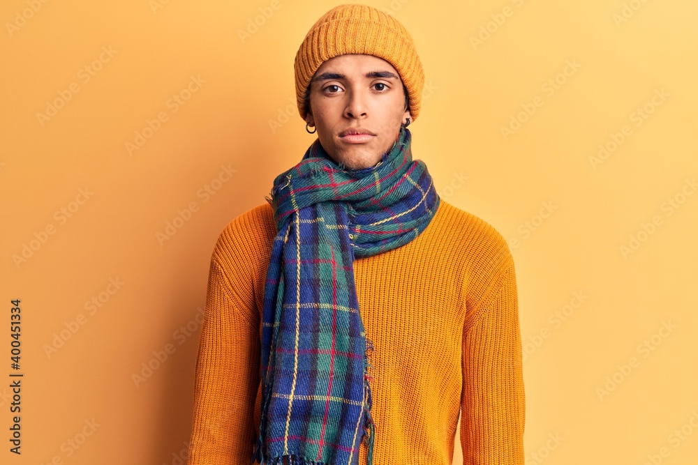 Young african amercian man wearing casual winter clothes with serious expression on face. simple and natural looking at the camera. Young african amercian man wearing casual winter clothes with serious expression on face. simple and natural looking at the camera.