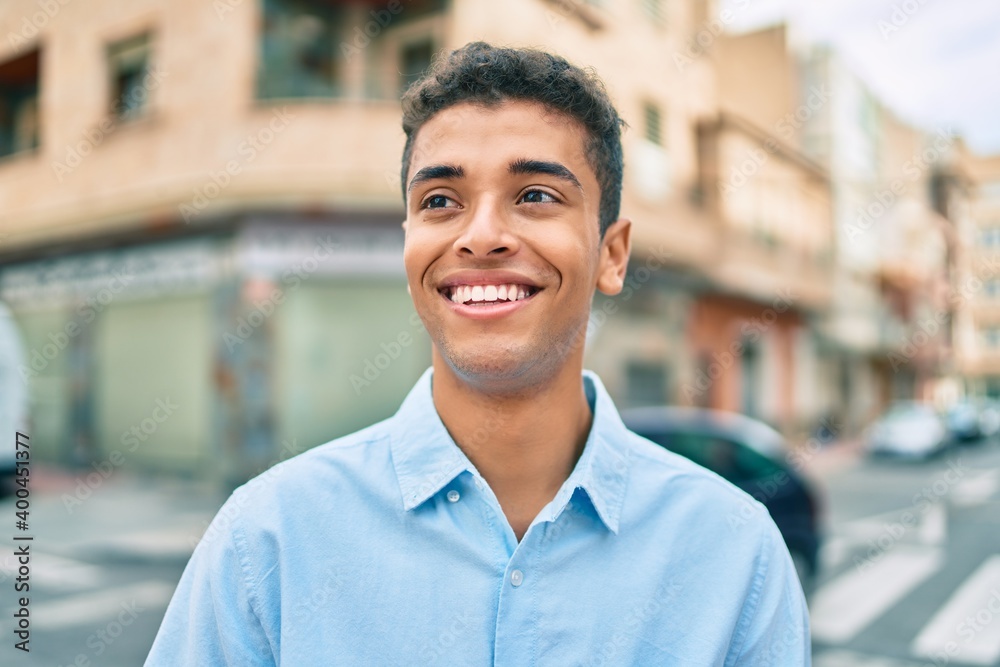 Young latin man smiling happy walking at the city. Young latin man smiling happy walking at the city.