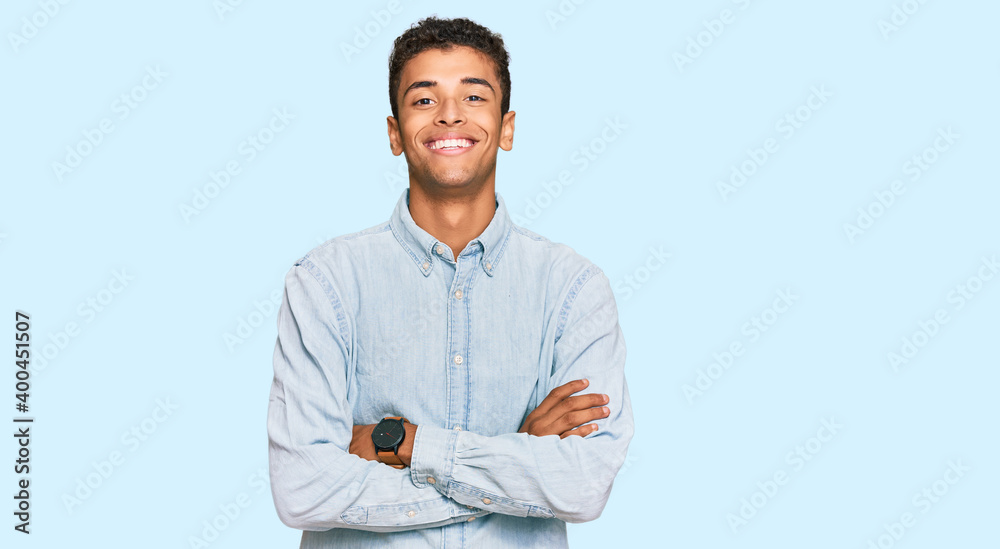 Young handsome african american man wearing casual clothes happy face smiling with crossed arms looking at the camera. positive person. Young handsome african american man wearing casual clothes happy face smiling with crossed arms looking at the camera. positive person.