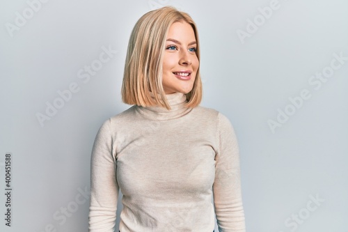 Young blonde woman wearing casual clothes looking to side, relax profile pose with natural face and confident smile.