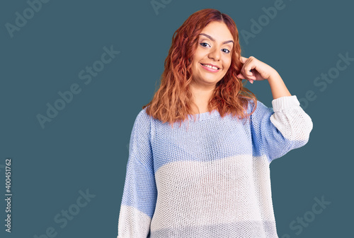 Young latin woman wearing casual clothes smiling pointing to head with one finger, great idea or thought, good memory