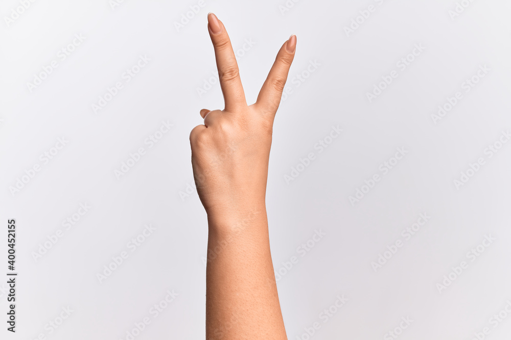 Hand of caucasian young woman counting number 2 showing two fingers, gesturing victory and winner symbol Hand of caucasian young woman counting number 2 showing two fingers, gesturing victory and winner symbol